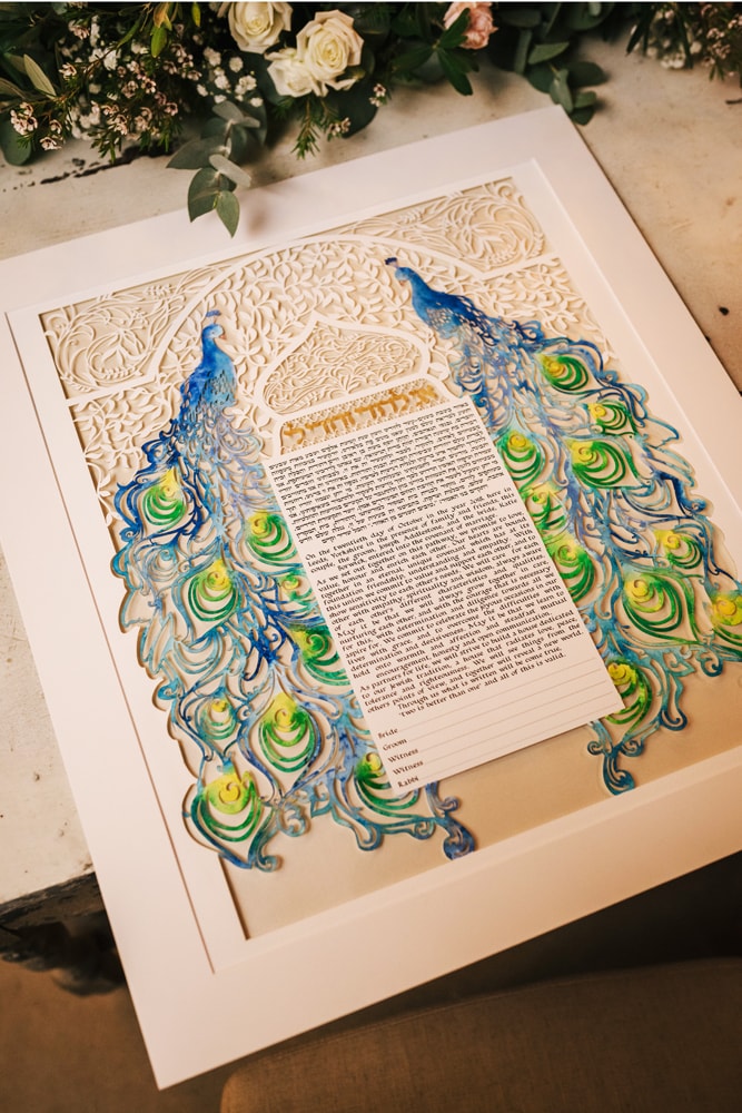 A quote from a bride on a background of her own customized Ketubah: 'Our Ketubah is the perfect blend of tradition and individuality'